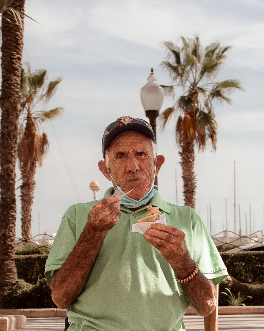 A close portrait of an older man eating ice cream in Alicante