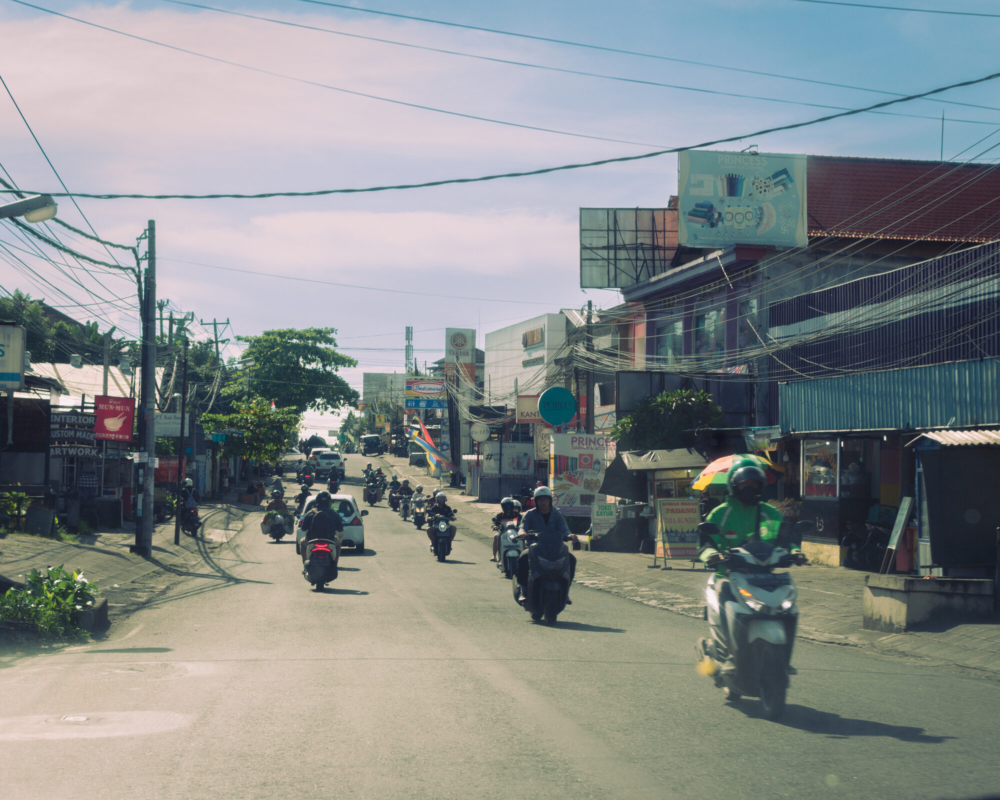 A colourful street lined with shops and motorbikes in Bali
